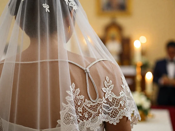 Traditional Filipino wedding cord and veil ceremony with ornate lace draped over couple's shoulders